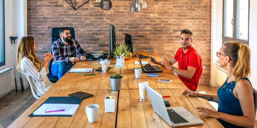 pessoas no escritório sentadas ao redor de uma mesa falando sobre employer branding