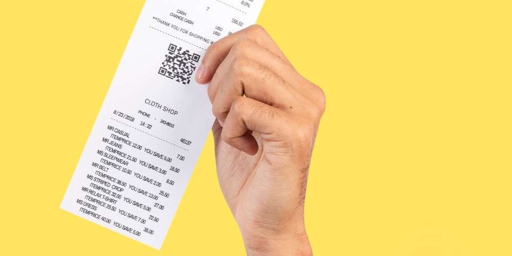 Imagem de uma pessoa segurando um cupom de compras