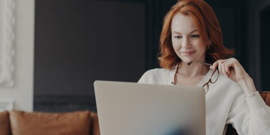 mulher profissional de RH olhando para notebook na mesa analisando hard skills do futuro colaborador