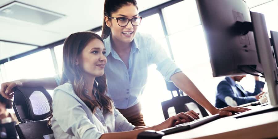 mulheres em escritório utilizando inteligência artificial no RH pelo computador