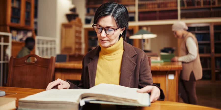 mulher branca sentada em escritório lendo sobre o que é lifelong learning
