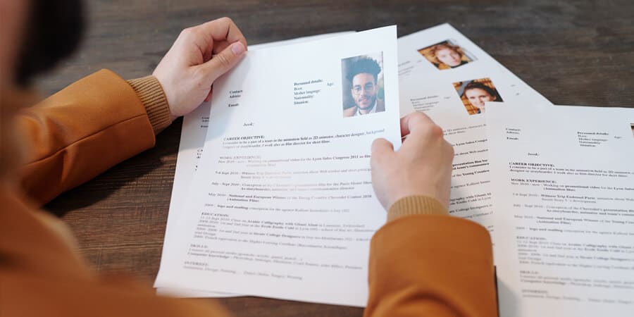 profissional de RH analisando documento e fazendo triagem de currículos