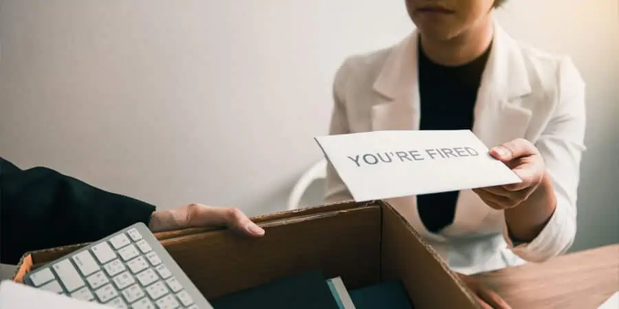 mulher segurando papel de demissão pensando nas verbas recisórias