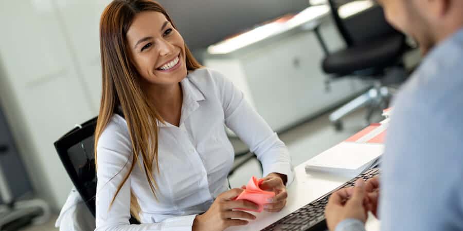 mulher sorrindo em um escritório em frente a funcionário falando sobre o que é lifelong learning