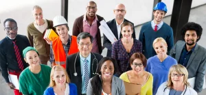 Um grupo diversificado de profissionais em trajes variados, incluindo uniformes médicos, capacetes de construção e ternos, reuniu-se em um local fechado.