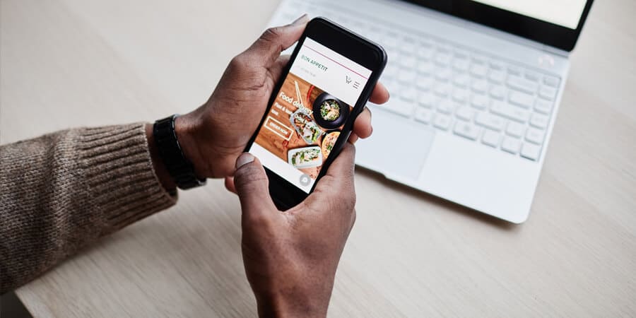 pessoa dentro do escritório olhando app de delivery pensando se é possível comprar com vale-alimentação pela internet