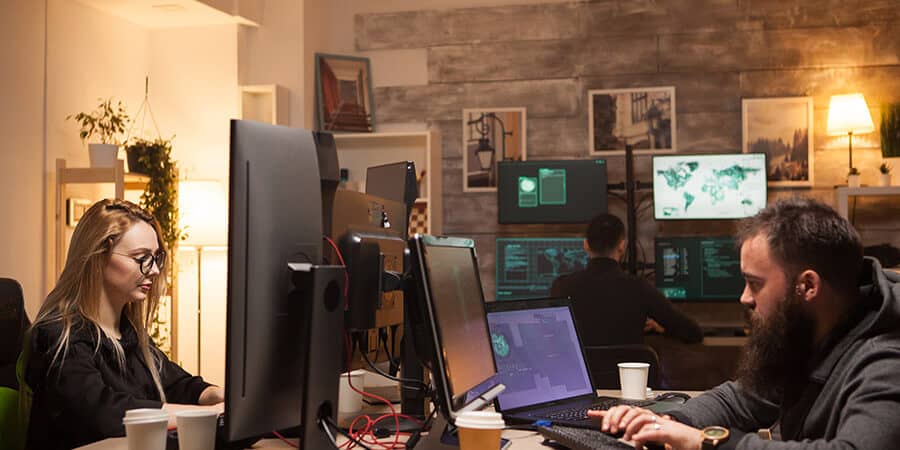 funcionários em escritório mexendo no computador representando a ética profissional