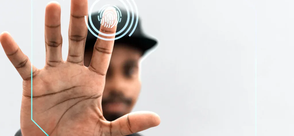 Homem negro com a mão aberta à frente, focando o dedo indicador em um ícone digital de biometria e fundo claro.