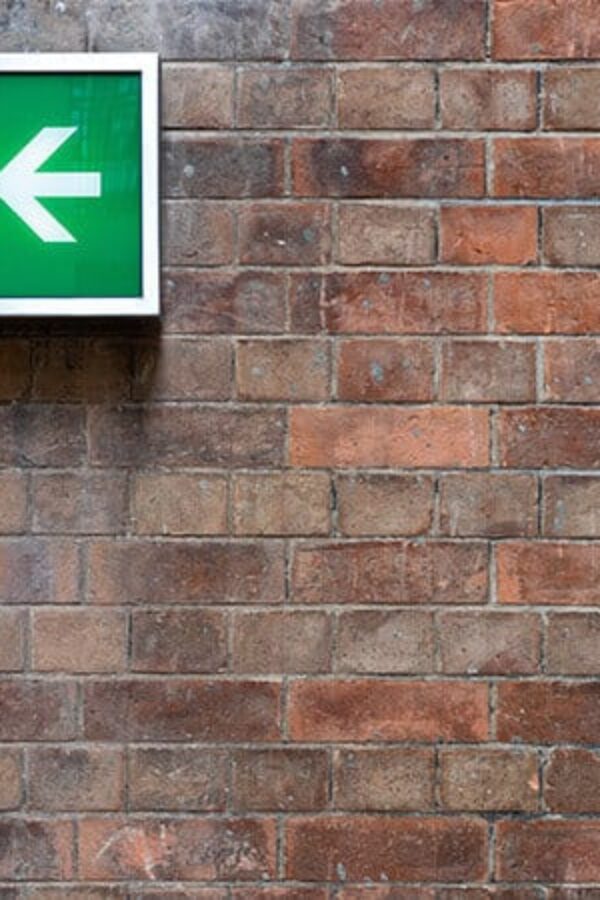 cipa: parede de tijolos com placa de saída de segurança